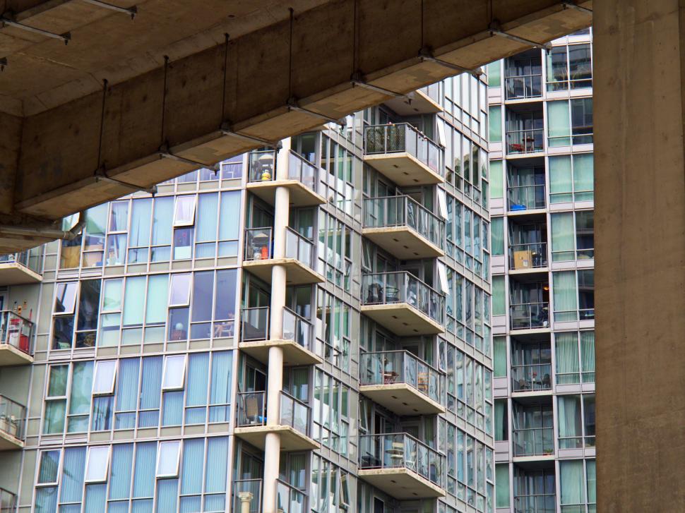 Free Image of Modern glass-fronted high-rise building under bridge 