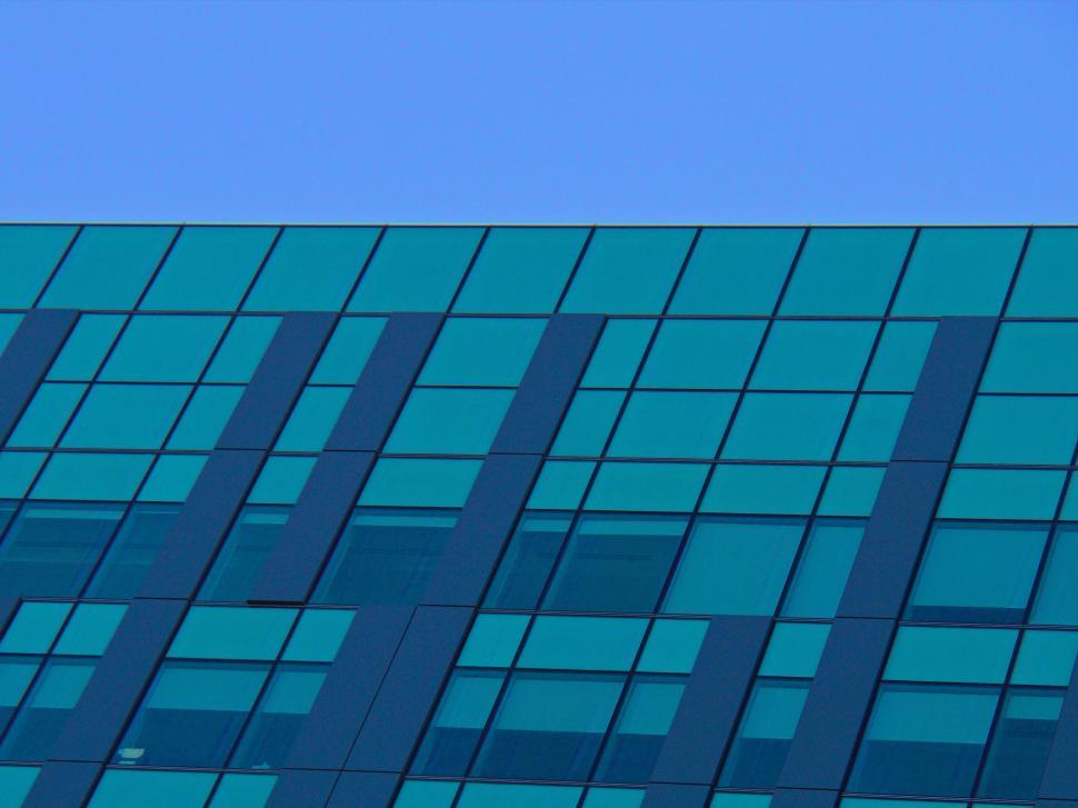 Free Image of Top section of a modern teal glass building exterior 