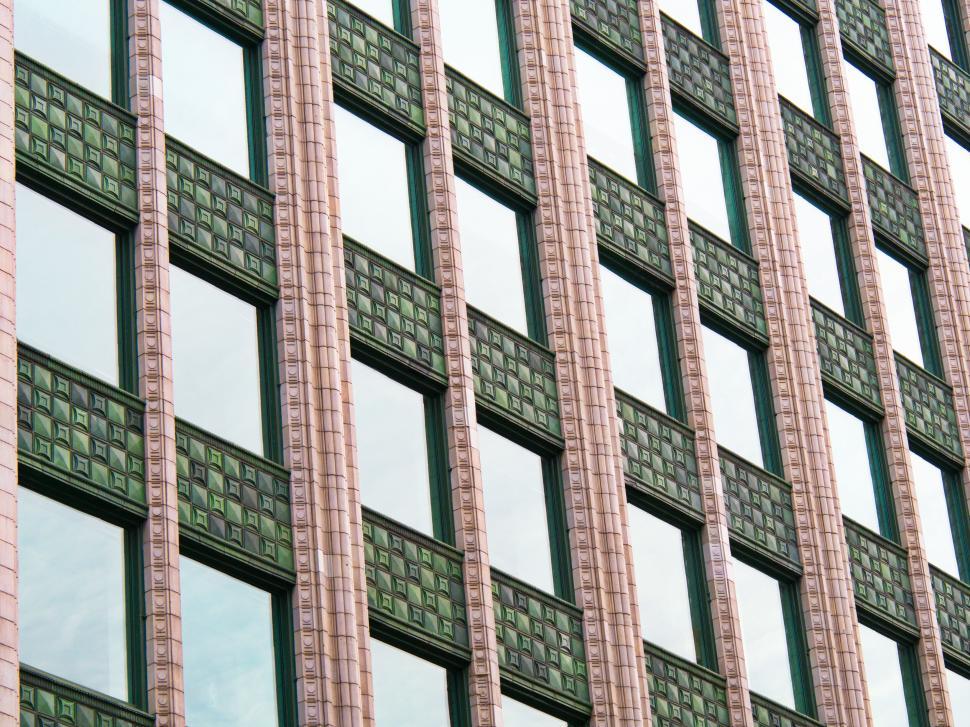 Free Image of Gridded facade of a building with repetitive window design 
