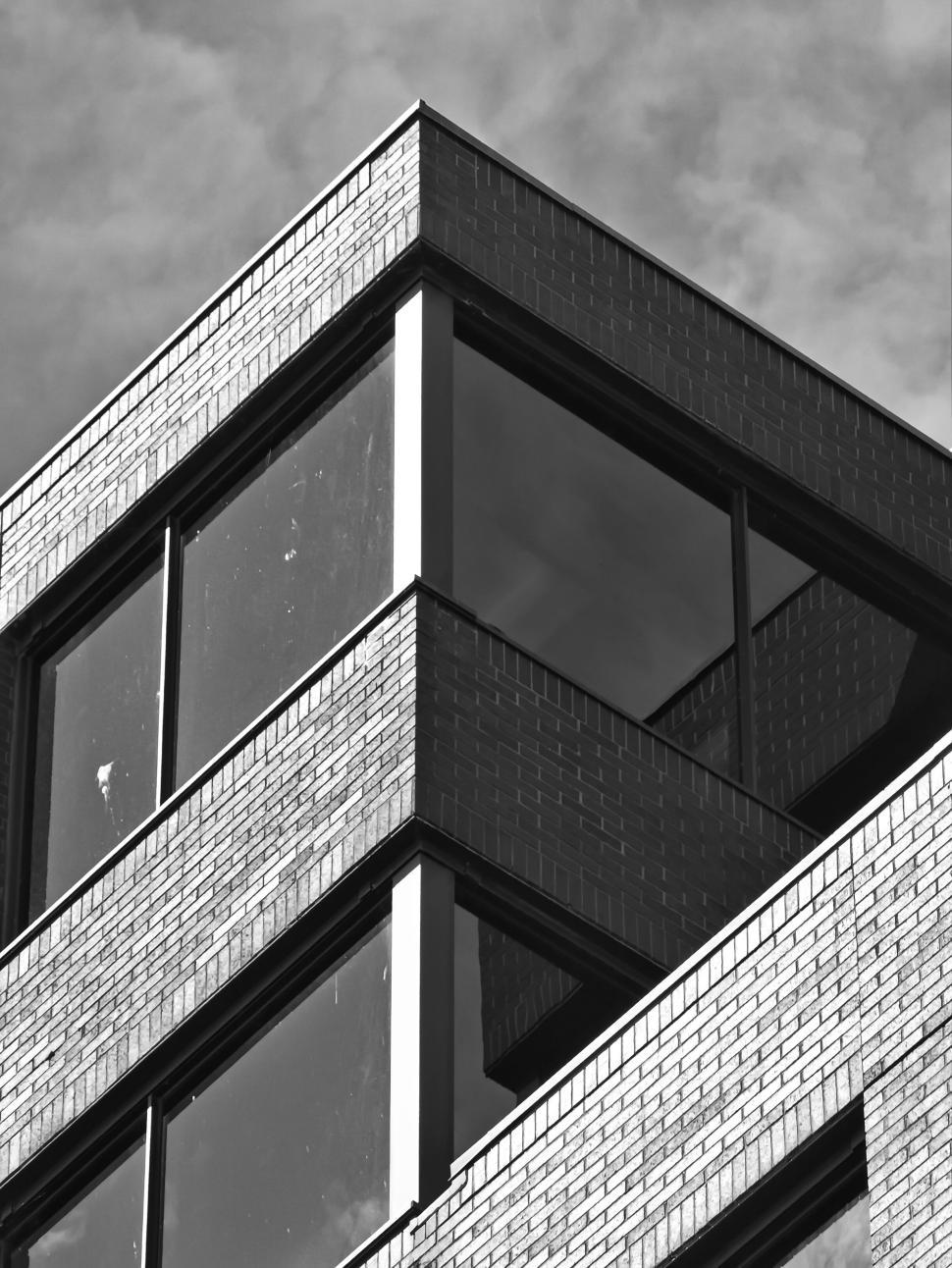 Free Image of Corner view of brick building with large windows. 