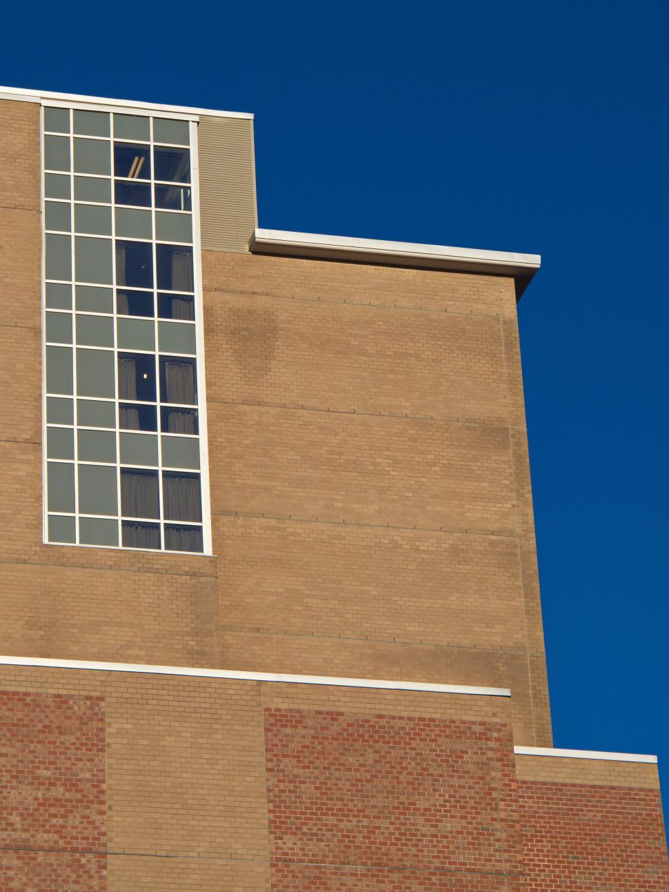 Free Image of Part of a tall building with a narrow window strip. 
