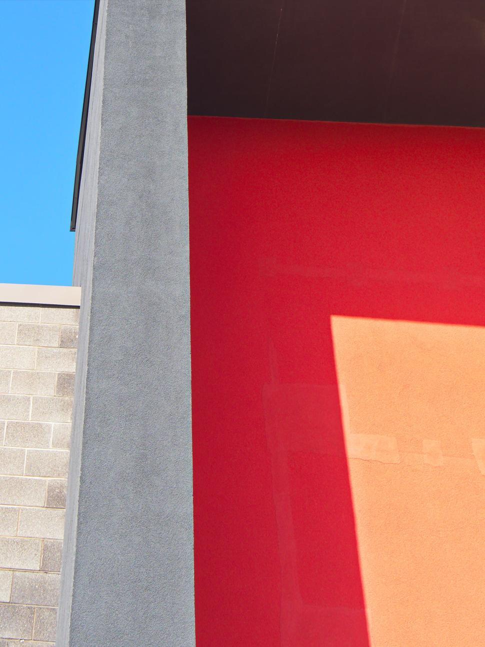 Free Image of Colorful urban wall with red, orange, and gray panels. 