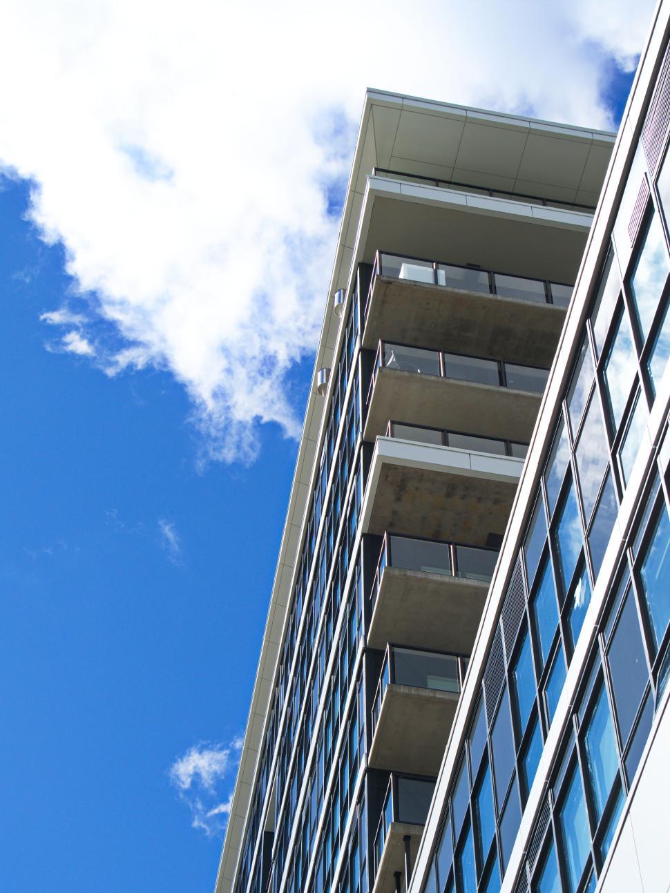 Free Image of High-rise building with glass balconies and blue sky 