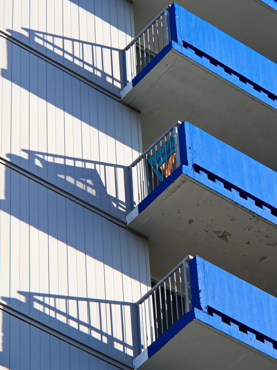 Free Image of Vivid blue balconies casting decorative shadows on wall 
