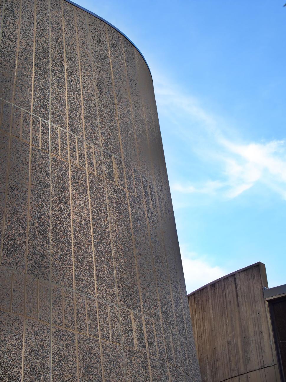 Free Image of Curved granite wall with clear blue sky background 
