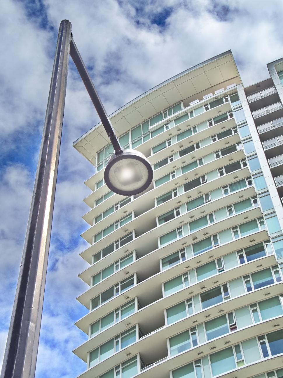 Free Image of Modern apartment building with street lamp in foreground 