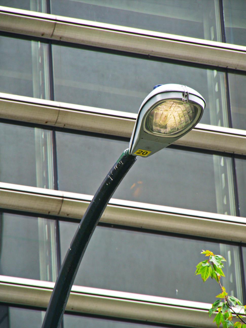 Free Image of Modern lamp post with sleek design against building backdrop. 