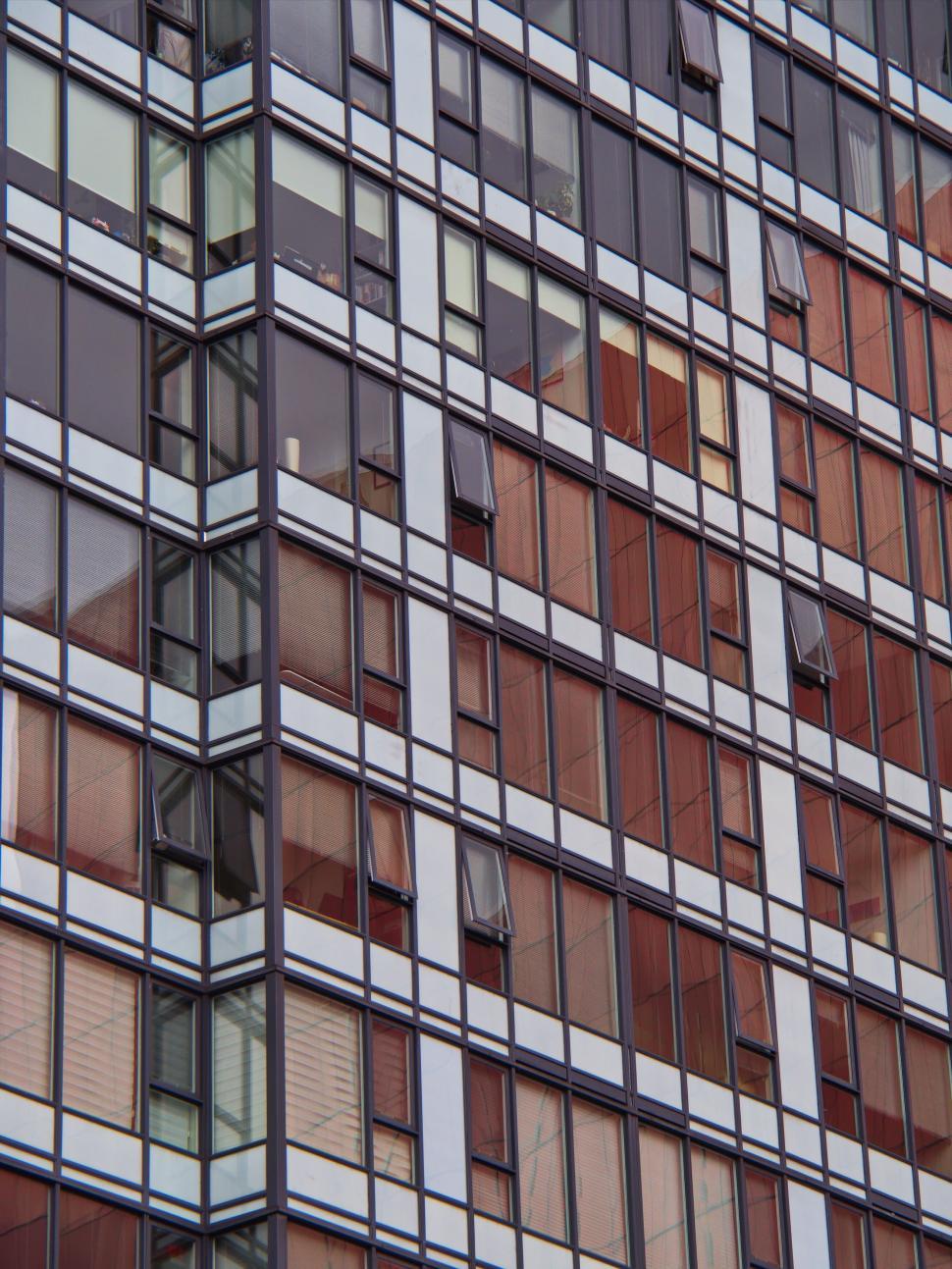 Free Image of Grid of glass windows on modern high-rise building facade 