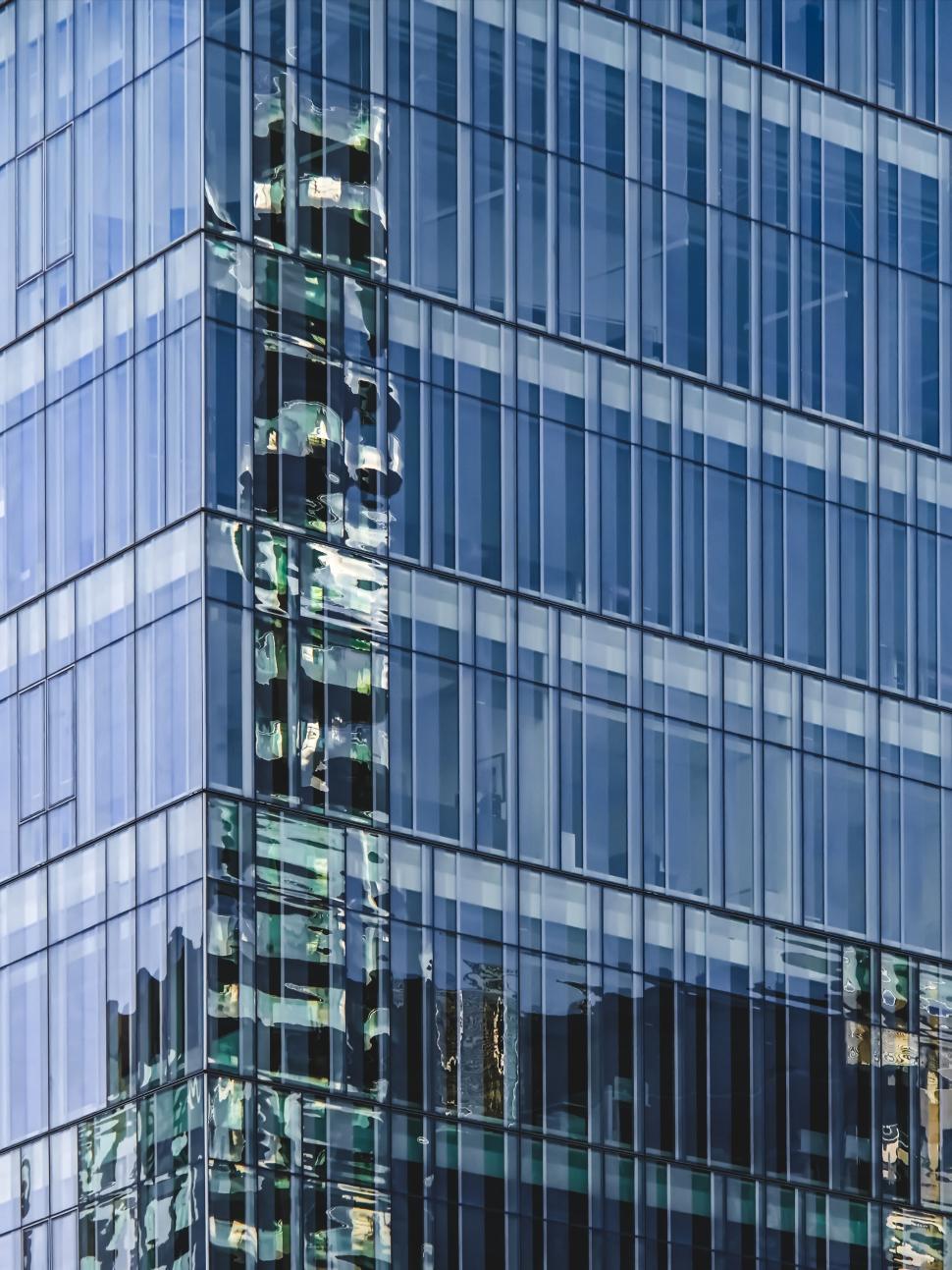 Free Image of Glass building exterior reflecting distorted cityscape 