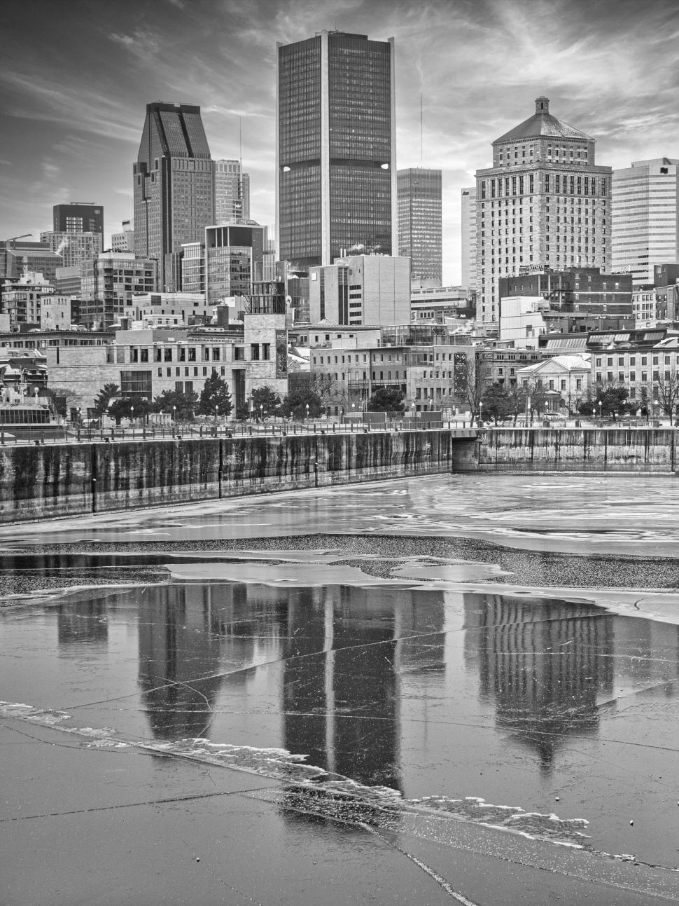 Free Image of Black and white cityscape with tall buildings reflecting. 