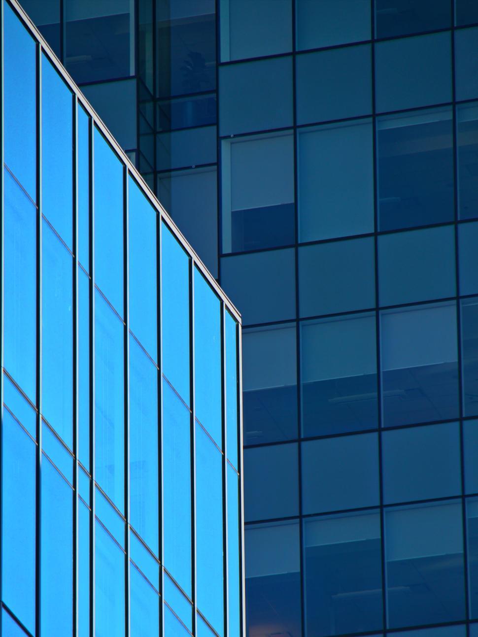Free Image of Blue glass building with reflections on a sunny day 