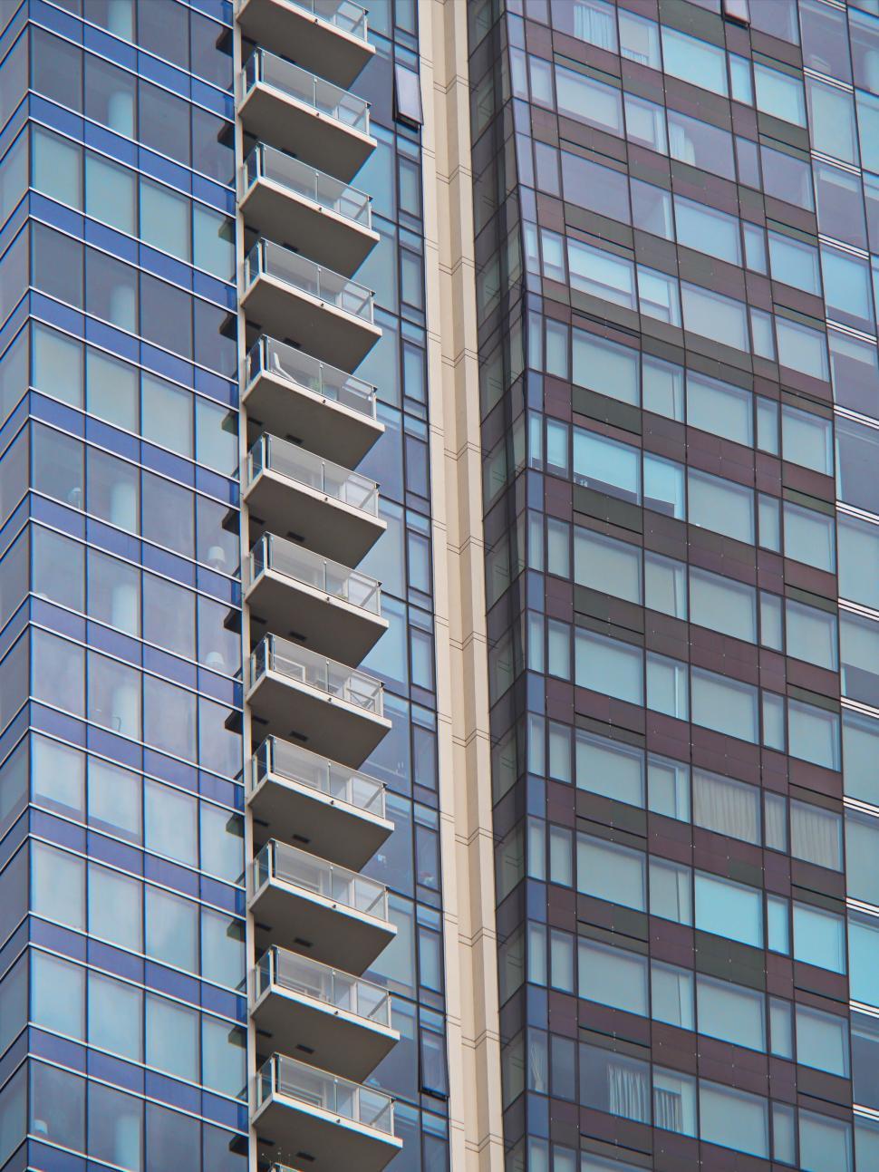 Free Image of High-rise building with glass balconies and colored panels 