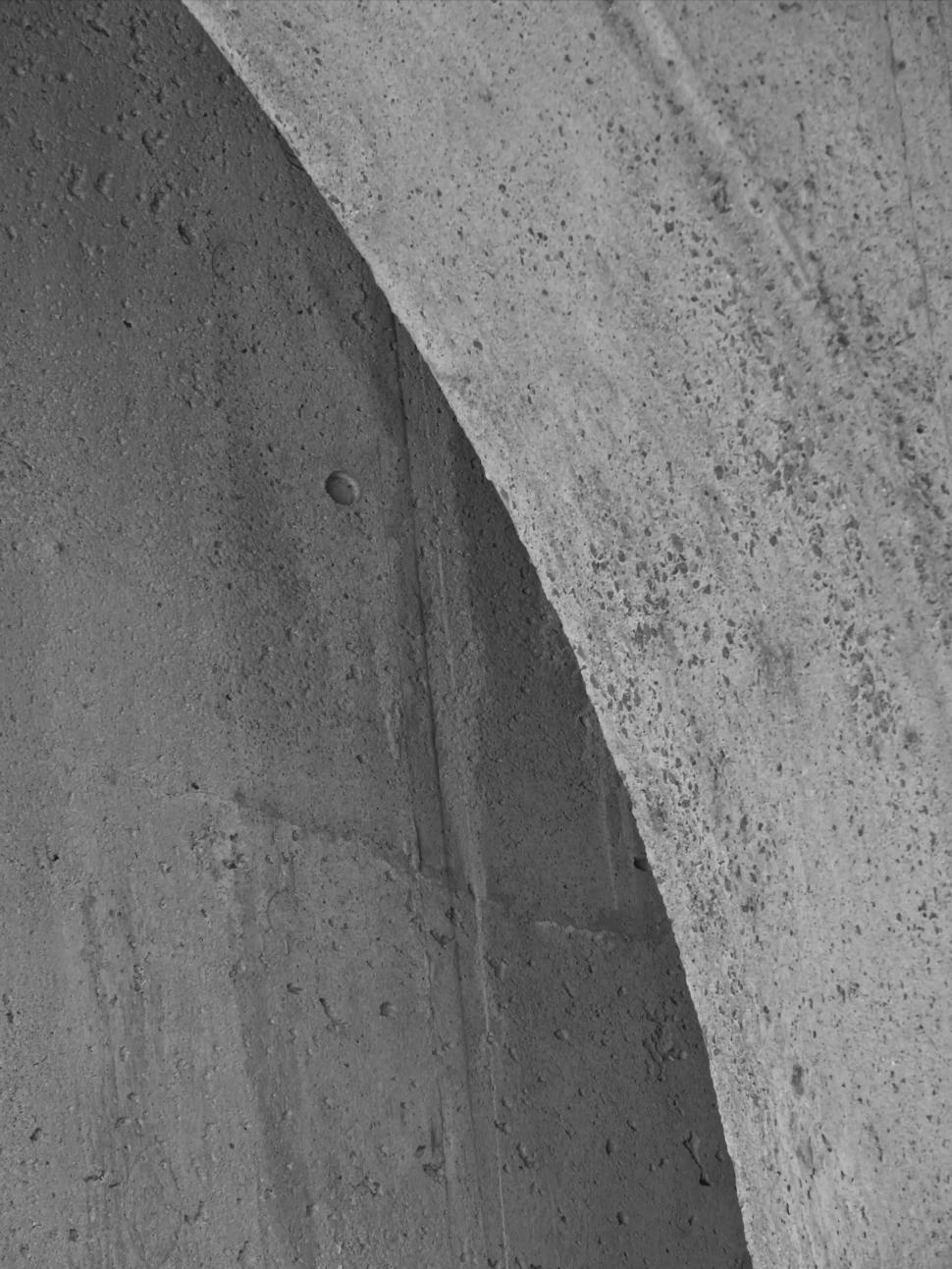 Free Image of Close-up of rough concrete surface with an arch detail. 