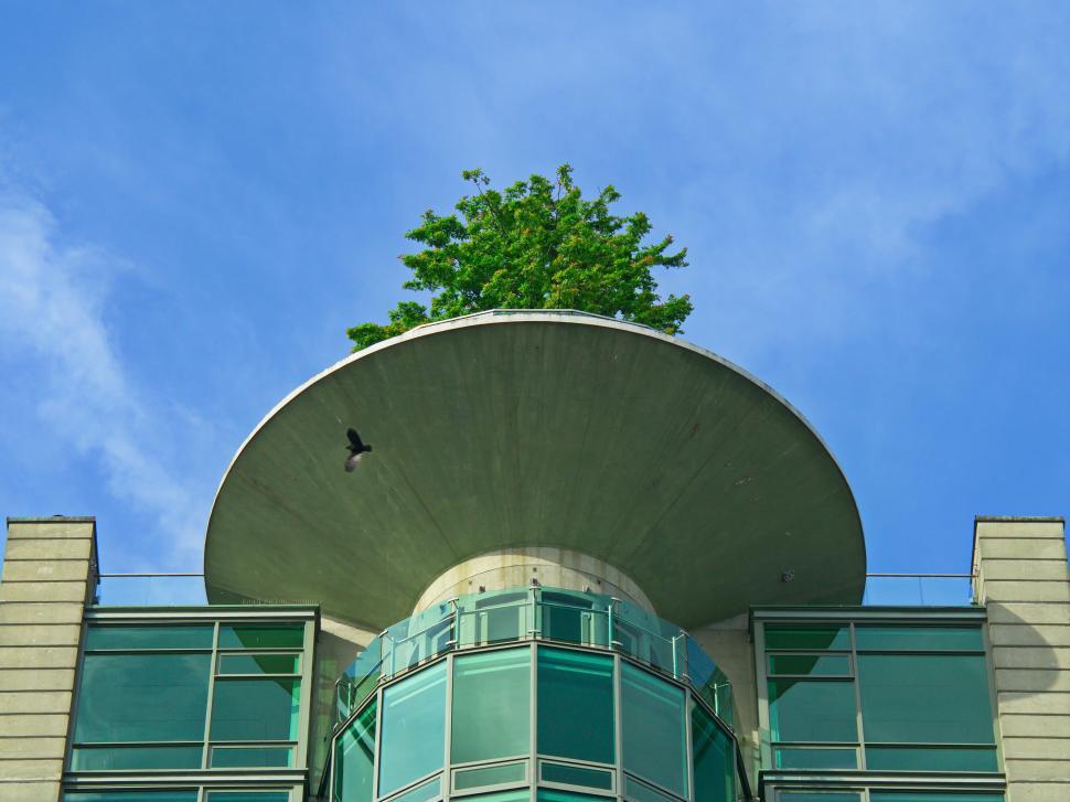 Free Image of Modern building with green rooftop tree and blue sky 