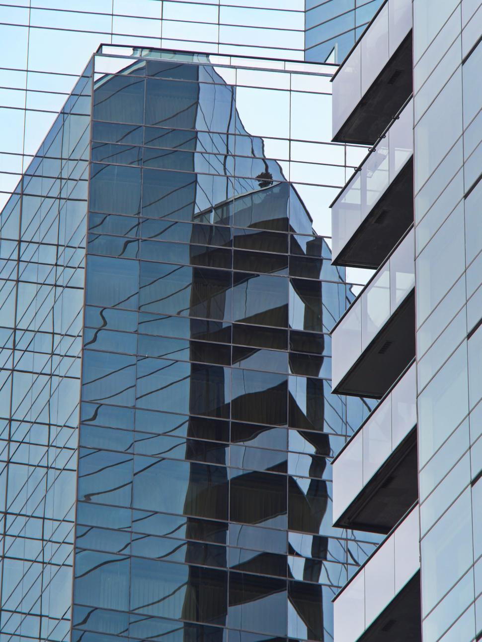 Free Image of Glass skyscraper reflection showing urban cityscape 