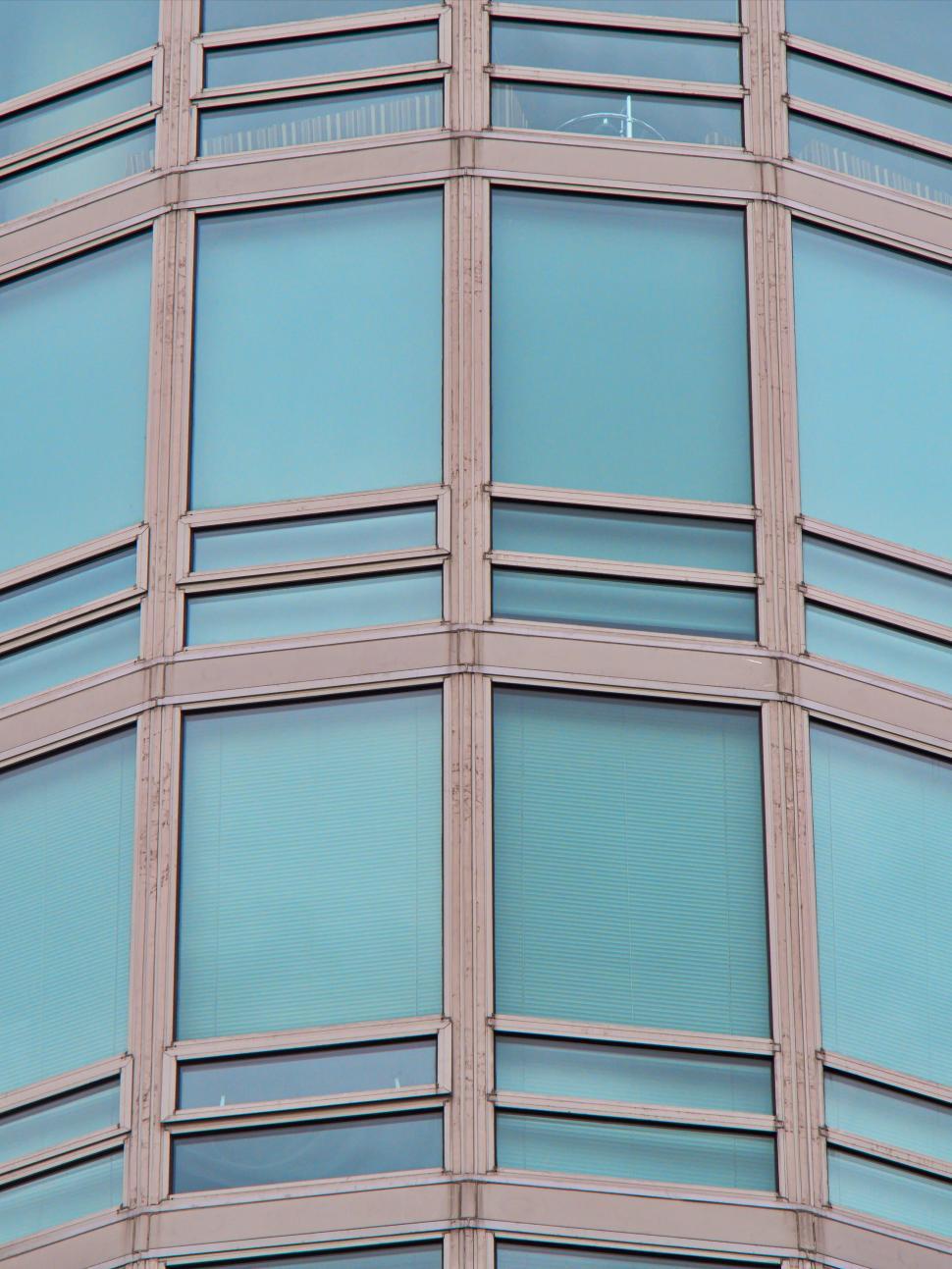 Free Image of Tall modern glass building with numerous vertical windows. 