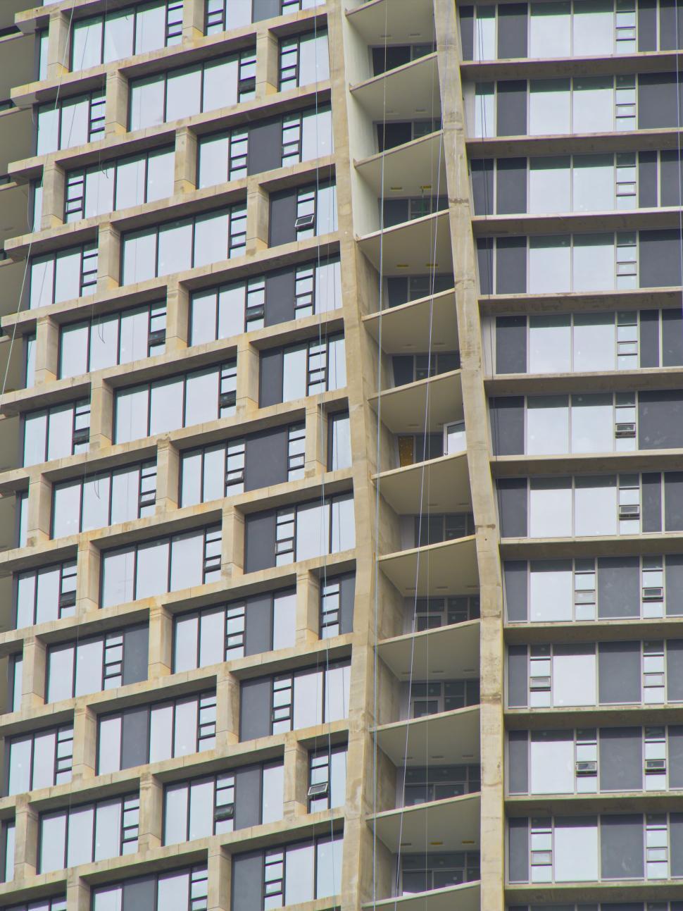 Free Image of Curved modern skyscraper with many windows and levels. 