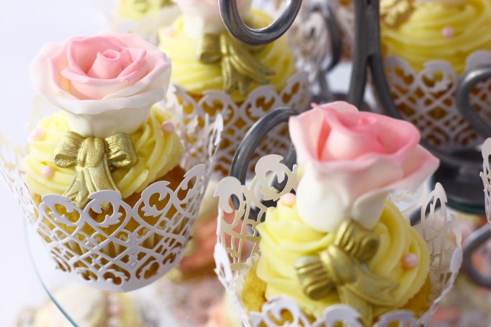 Free Image of Decorative cupcakes with pink and yellow flower icing. 