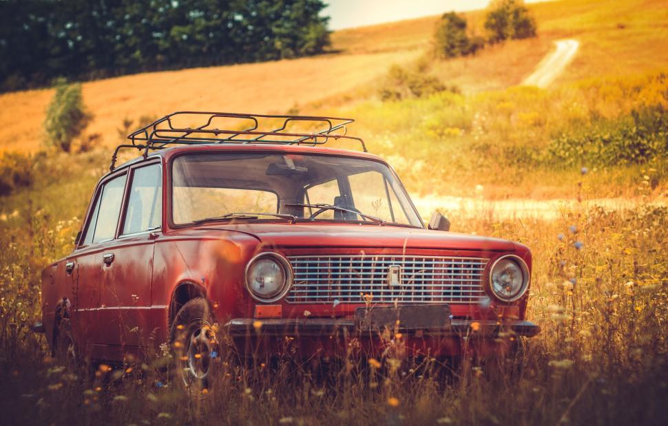 Free Image of Rusty vintage car parked in a scenic field 