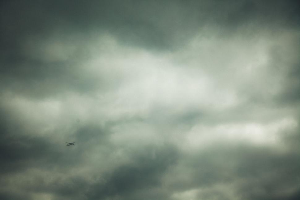 Free Image of Airplane in cloudy sky with dramatic lighting effect 