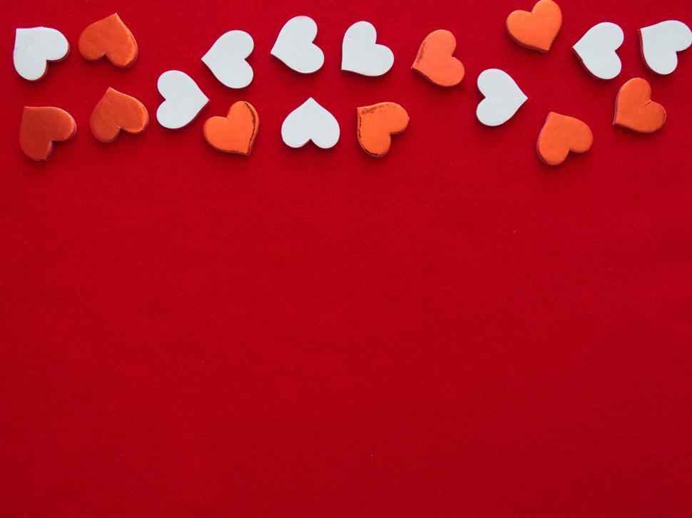 Free Image of Red background with scattered orange and white hearts. 