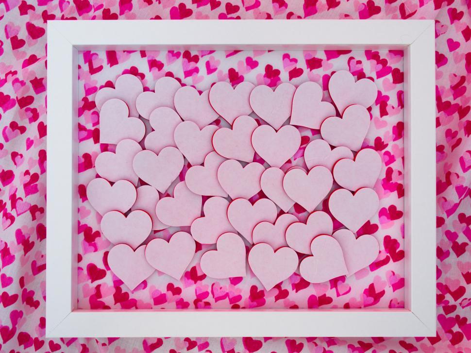 Free Image of Pink heart shapes inside a white frame on heart background 