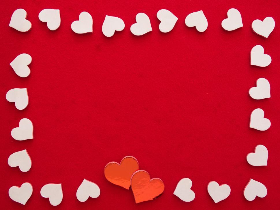 Free Image of Heart shapes on red background with two orange hearts. 
