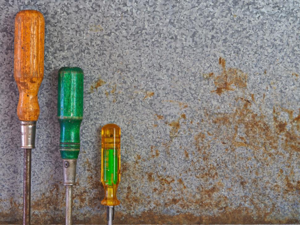 Free Image of Three screwdrivers on rusted metal surface background 