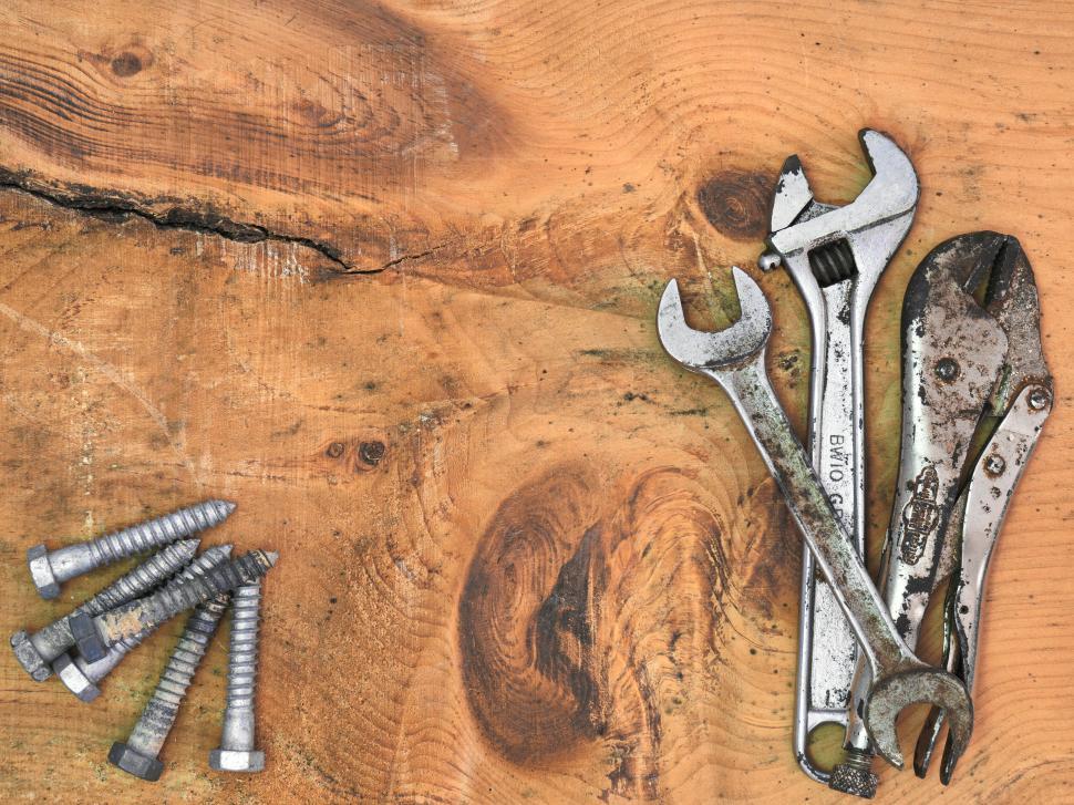 Free Image of Close-up shot of tools and screws on wooden surface. 