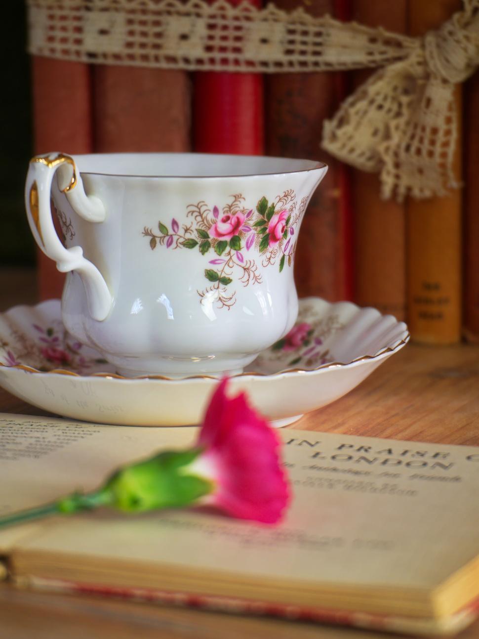 Free Image of Ornate teacup with floral design on a saucer in book. 