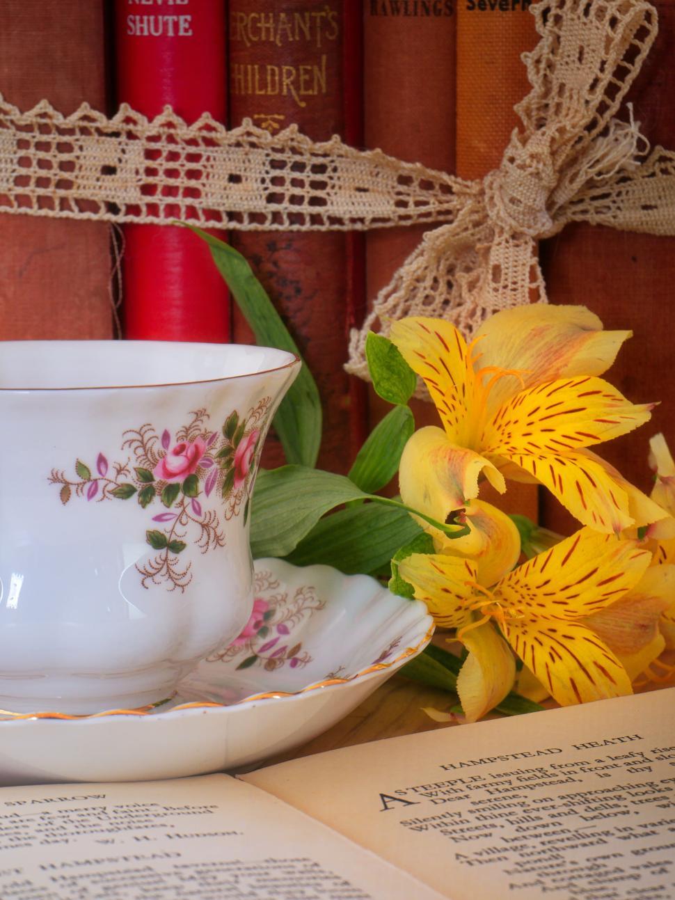 Free Image of Floral teacup and saucer with yellow flowers and books 