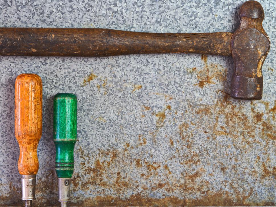 Free Image of Old hammer and screwdrivers on rusted metal surface. 