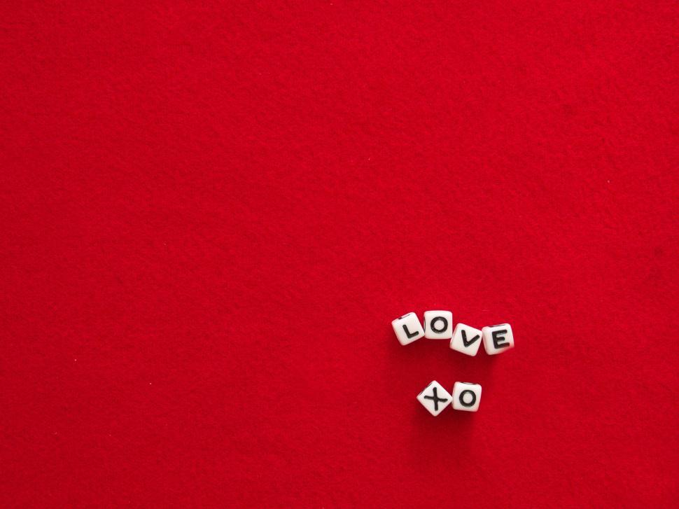 Free Image of Love message on red background with cube-shaped letters. 