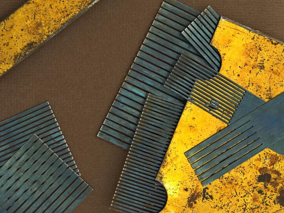 Free Image of Industrial metal combs on a brown background create a pattern. 