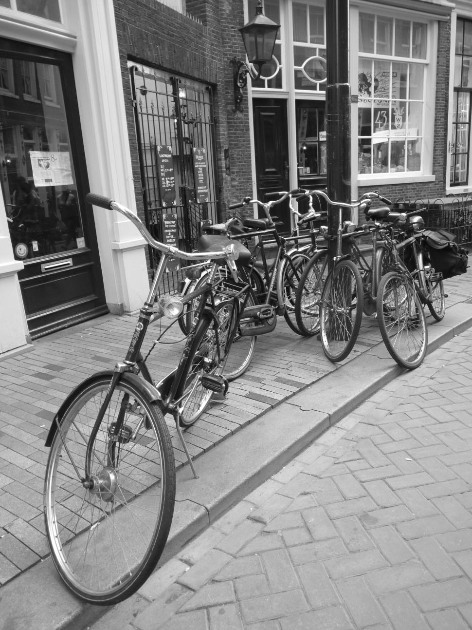 Free Image of Vintage bicycles lined up on a cobblestone street 