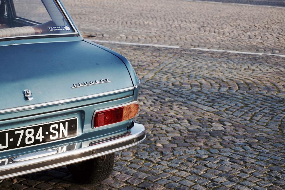 Free Image of Vintage Peugeot car on a cobblestone street 