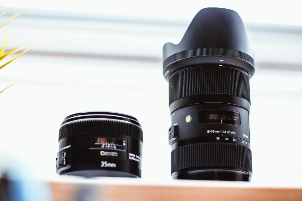 Free Image of Two camera lenses on a white surface in bright light 