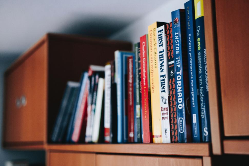 Free Image of Bookshelf filled with various colorful books displayed neatly. 