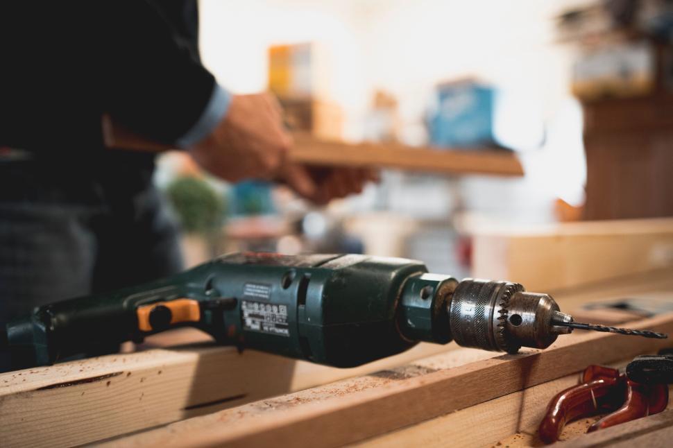 Free Image of Person woodworking with a power drill tool on a workbench. 