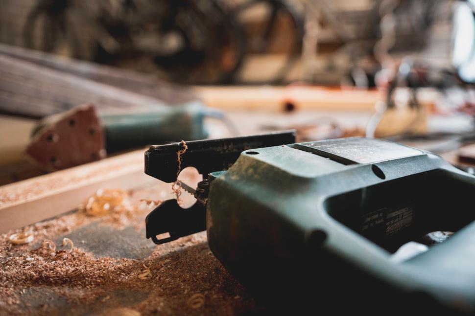Free Image of Power jigsaw tool with wood shavings scattered around. 