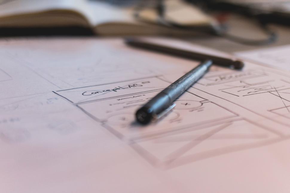 Free Image of Close-up of a pen and sketches of design concepts on paper. 