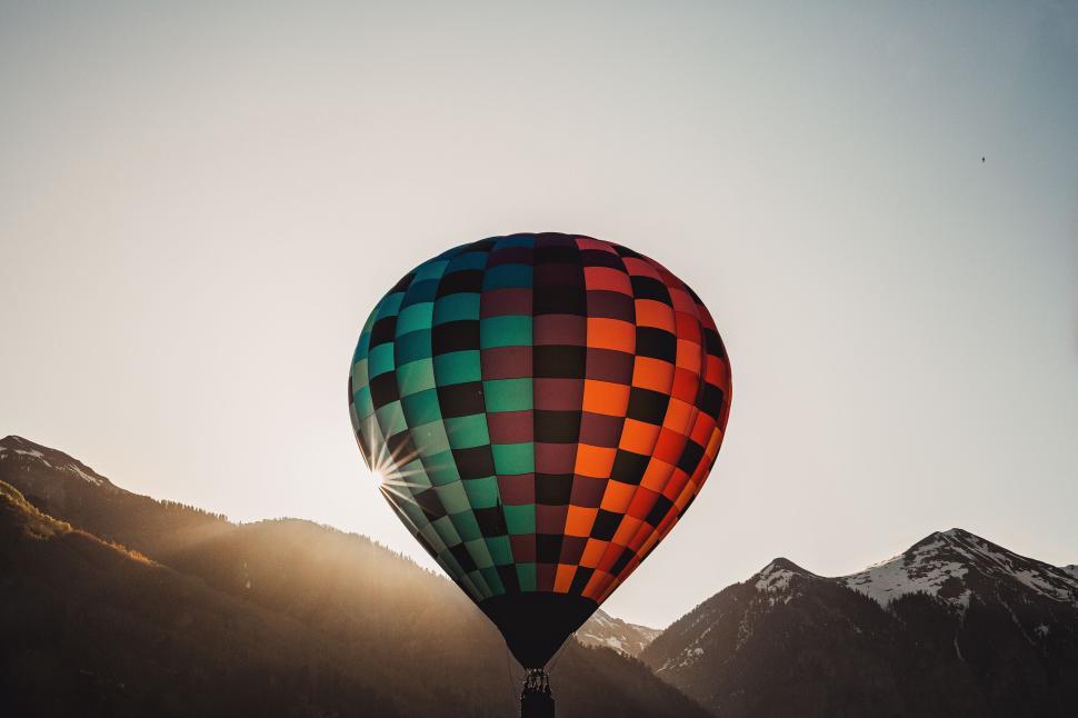 Free Image of Colorful Hot Air Balloon Flying Over Mountainous Terrain 