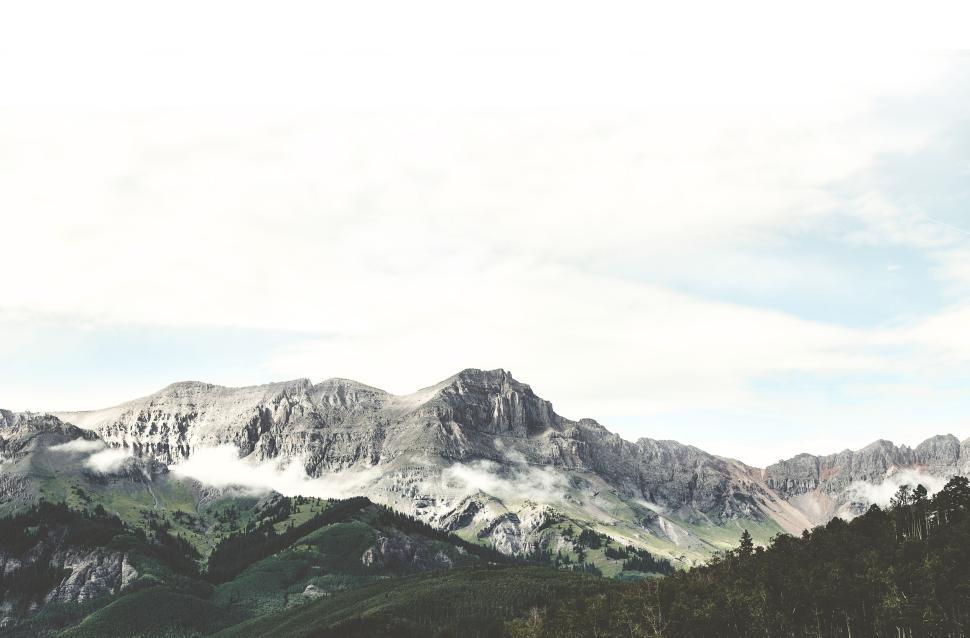 Free Image of Mountain range with green hills and misty clouds 