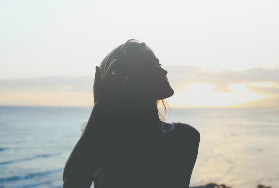 Free Image of Silhouette of a person by the seaside during sunset. 