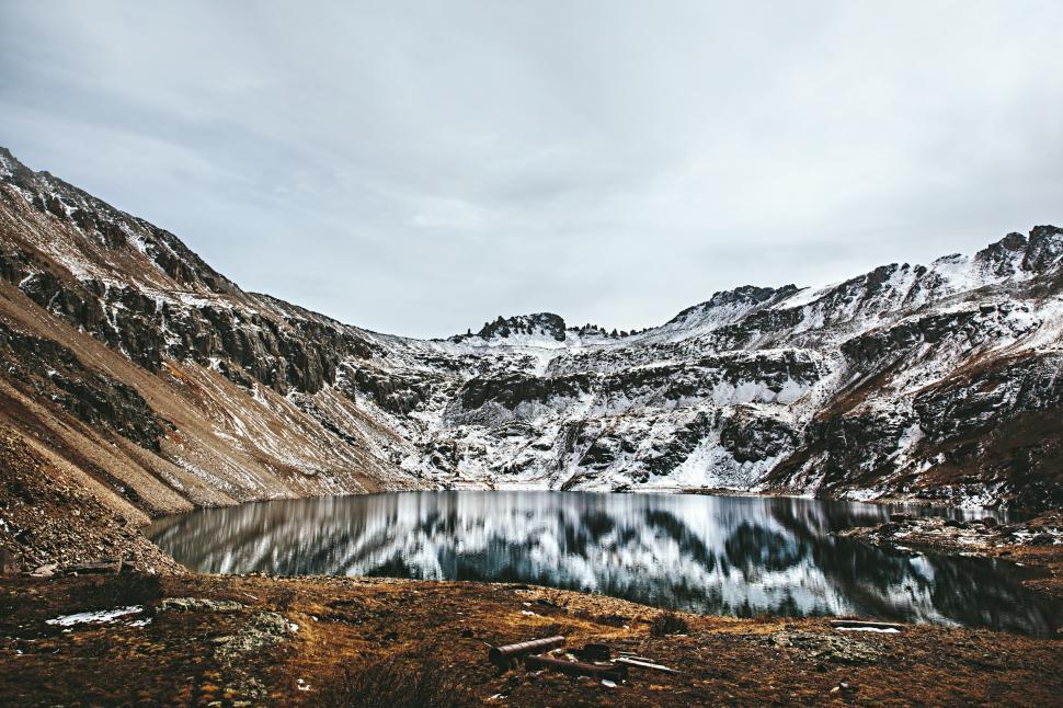 Free Image of High-altitude lake surrounded by rocky, snowy mountains. 