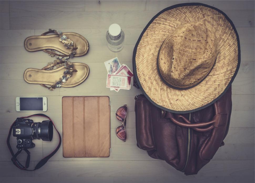 Free Image of Travel essentials laid out including hat and camera. 