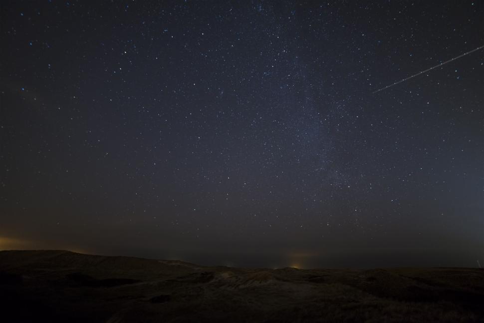 Free Image of Starlit night sky above a serene open field landscape. 
