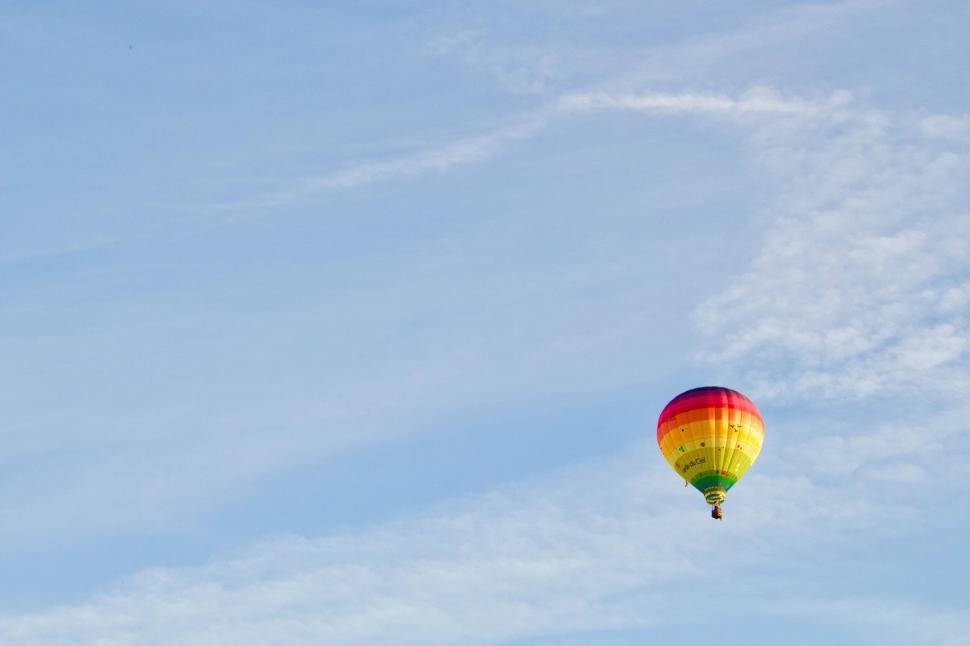 Free Image of Rainbow colored hot air balloon floating in the sky 