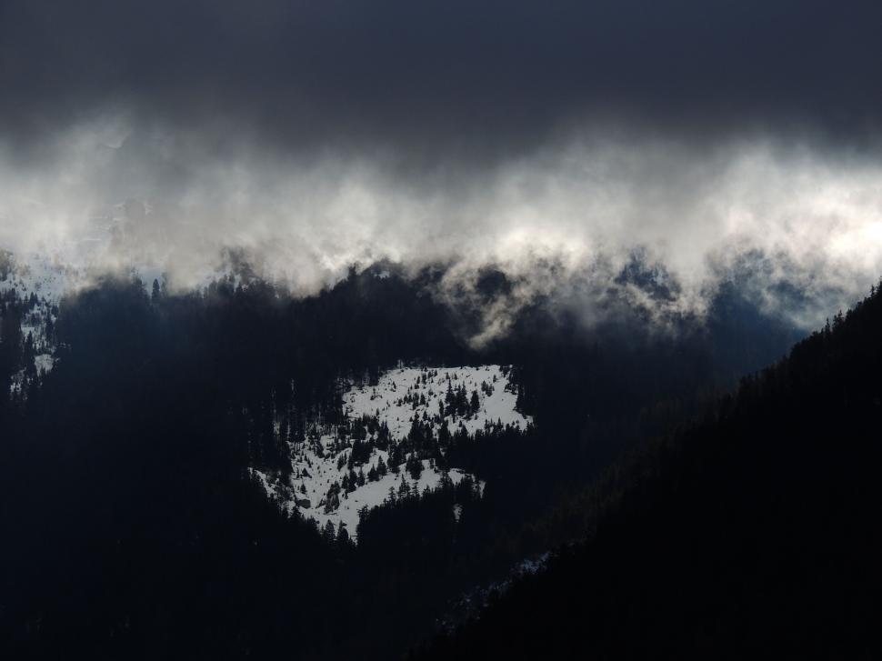Free Image of Dark clouds over snowy mountain peaks and valleys 