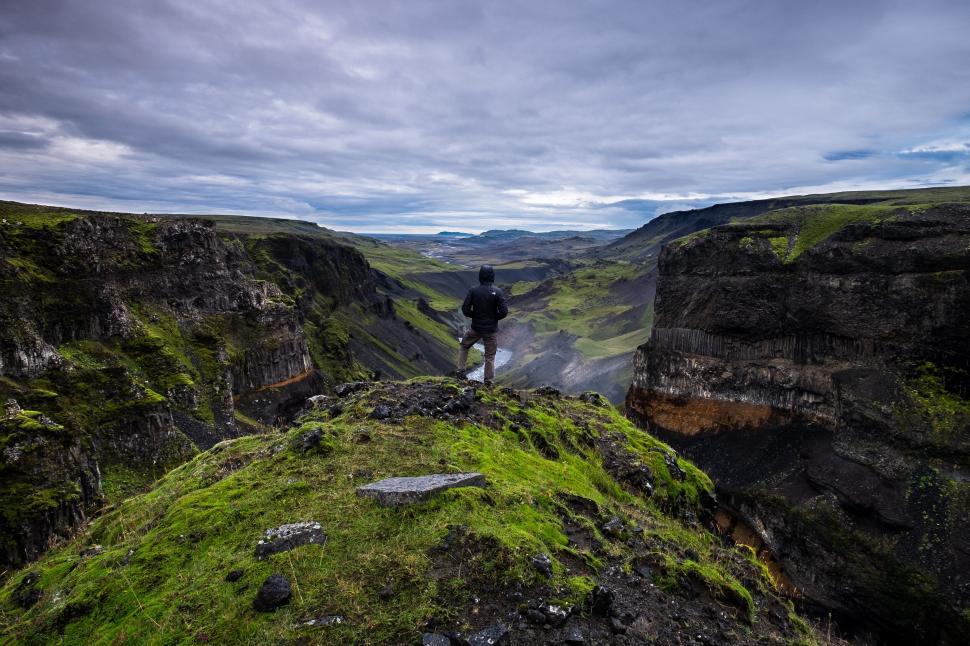 Free Image of Adventurer standing on a stunning canyon cliff edge 